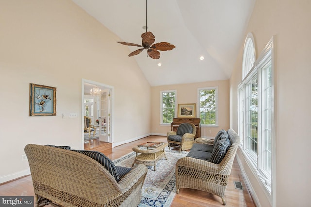 living area featuring high vaulted ceiling, a ceiling fan, baseboards, visible vents, and light wood-style floors