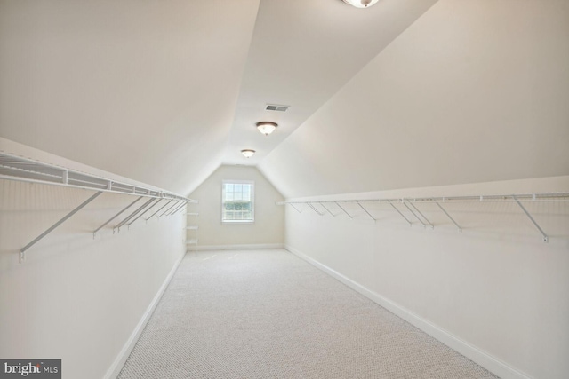 walk in closet with vaulted ceiling, carpet, and visible vents