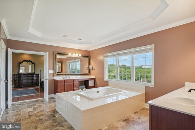 bathroom featuring stone finish floor, a garden tub, vanity, and crown molding