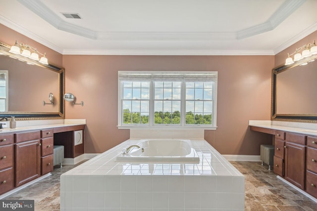 bathroom featuring a garden tub, vanity, visible vents, ornamental molding, and a raised ceiling