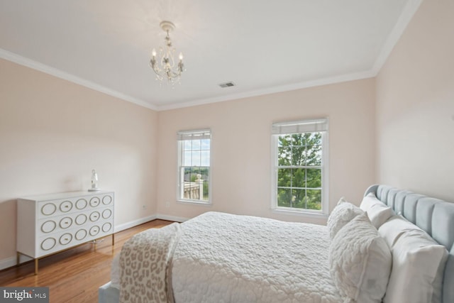 bedroom with visible vents, baseboards, wood finished floors, crown molding, and a notable chandelier