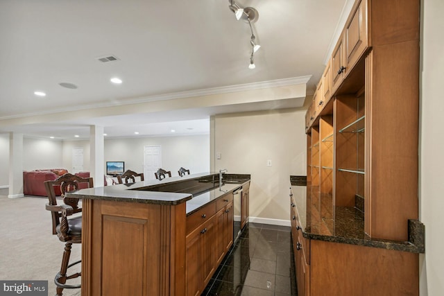 kitchen with recessed lighting, visible vents, stainless steel dishwasher, brown cabinetry, and baseboards