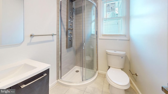 full bath with toilet, vanity, baseboards, a shower stall, and tile patterned floors