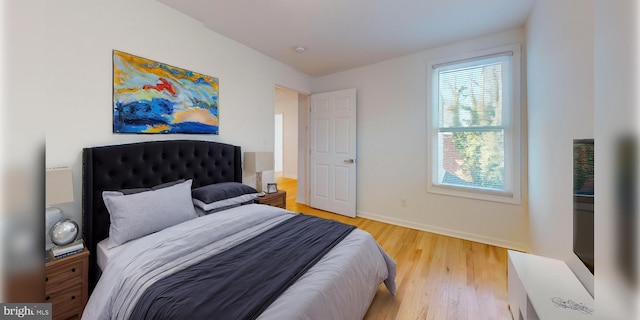 bedroom featuring baseboards and light wood finished floors