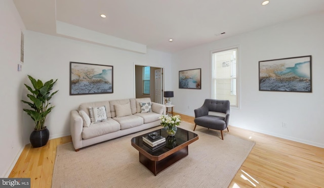 living room featuring baseboards, wood finished floors, and recessed lighting