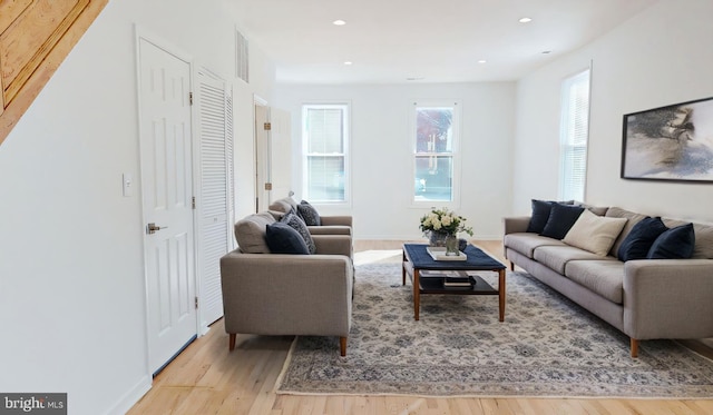 living room with light wood-style floors, recessed lighting, and baseboards