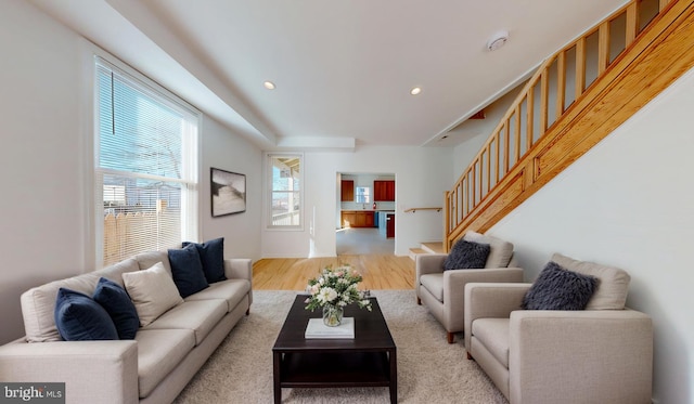 living area featuring light wood-type flooring, stairs, and recessed lighting