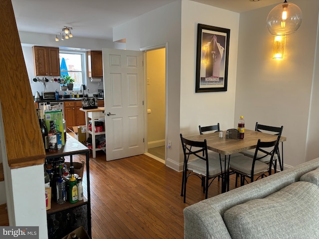 dining area featuring baseboards and dark wood finished floors