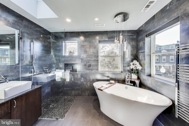 bathroom with a wealth of natural light, walk in shower, and tile walls