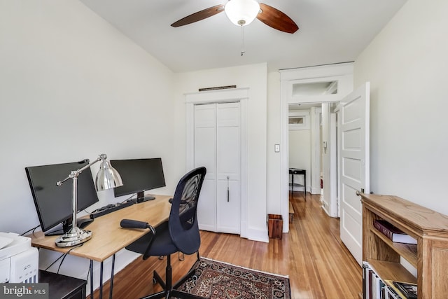 office with light wood finished floors and ceiling fan