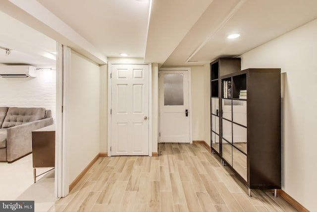 corridor featuring recessed lighting, a wall mounted air conditioner, light wood-style flooring, and baseboards