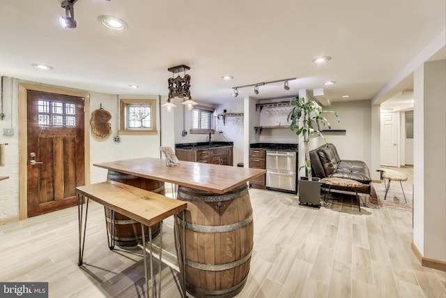 interior space with recessed lighting, dishwasher, open shelves, light wood finished floors, and track lighting