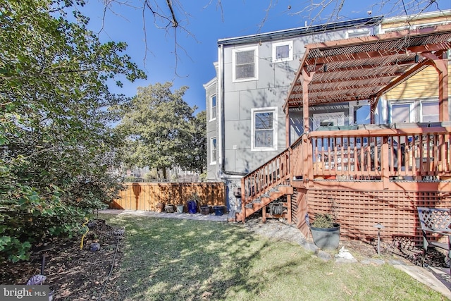 rear view of house with a yard and fence