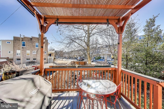 wooden terrace with a grill and a pergola