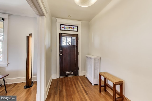 foyer entrance with wood finished floors and baseboards