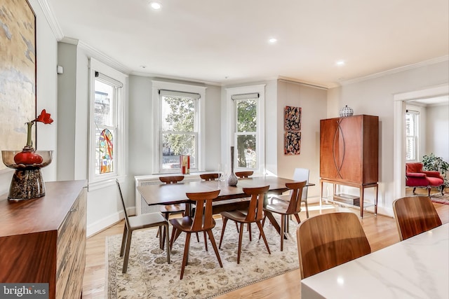 dining space featuring ornamental molding, recessed lighting, light wood-style flooring, and baseboards