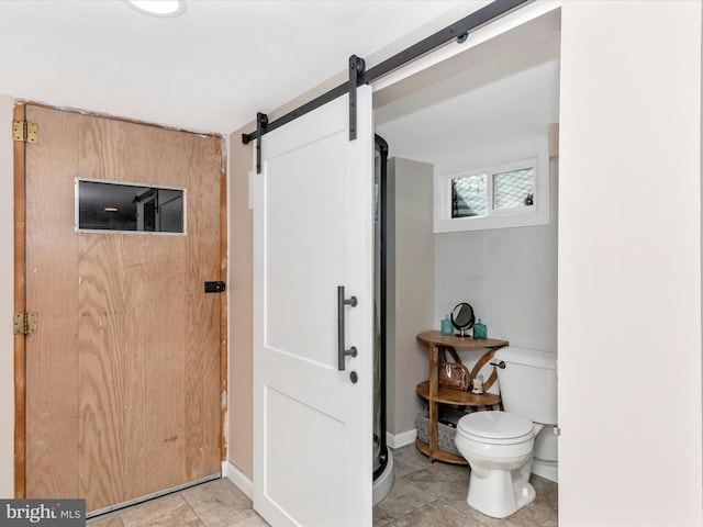 full bath with toilet, a shower stall, and baseboards