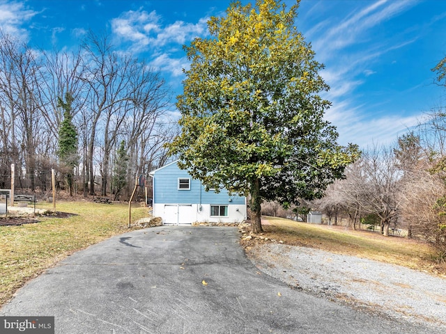 view of front of property with driveway, an attached garage, and a front yard