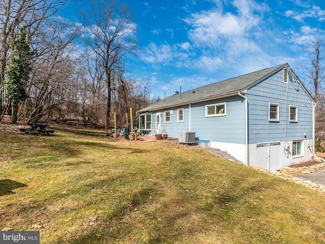 back of house featuring a yard and cooling unit