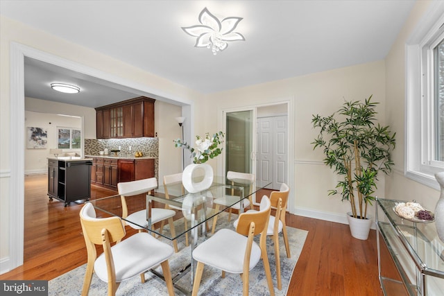 dining room featuring wood finished floors and baseboards