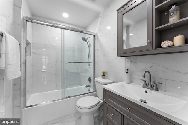 full bathroom featuring marble finish floor, tile walls, toilet, enclosed tub / shower combo, and vanity