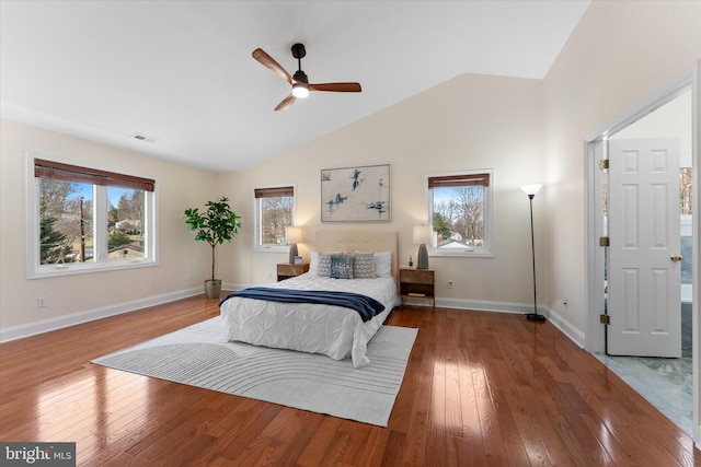 bedroom featuring lofted ceiling, wood-type flooring, multiple windows, and visible vents