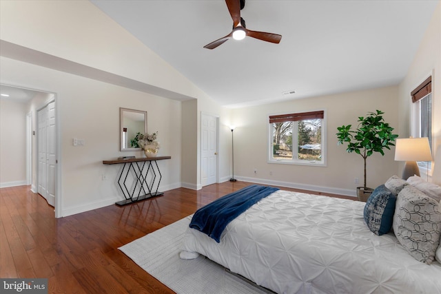 bedroom featuring visible vents, baseboards, vaulted ceiling, and wood finished floors