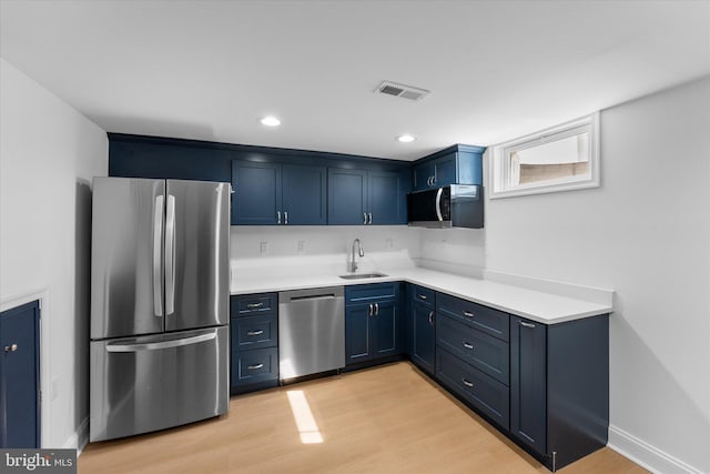 kitchen featuring blue cabinetry, light countertops, visible vents, appliances with stainless steel finishes, and a sink