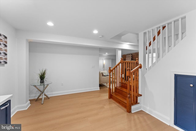 interior space with light wood finished floors, baseboards, stairway, and recessed lighting