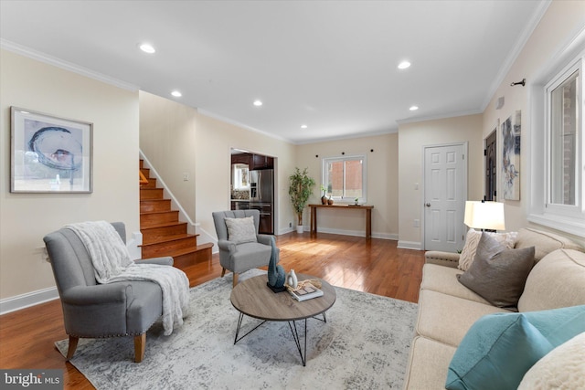 living room with baseboards, stairway, wood finished floors, and crown molding