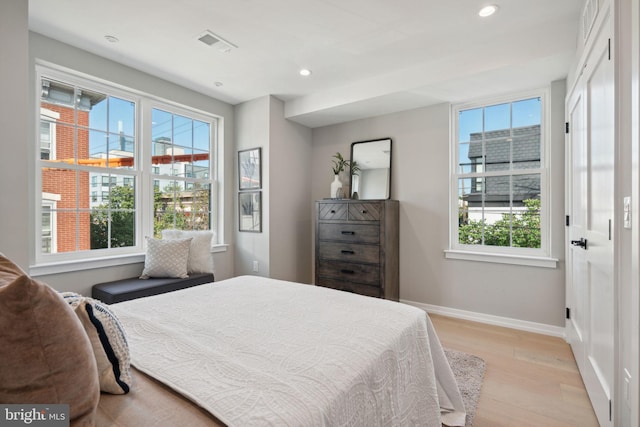 bedroom with light wood-style floors, recessed lighting, visible vents, and baseboards