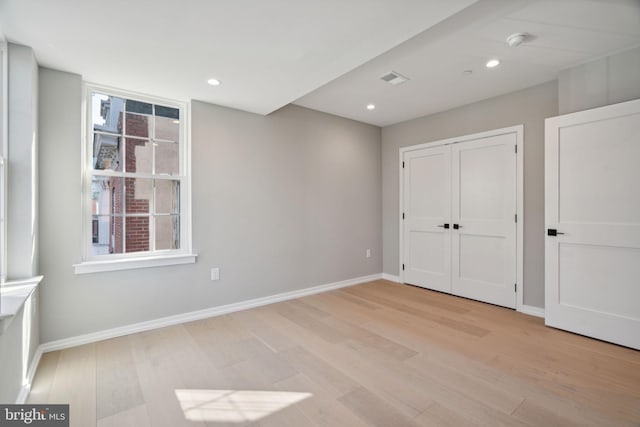 unfurnished bedroom featuring recessed lighting, light wood-type flooring, and baseboards