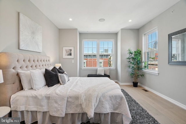 bedroom featuring baseboards, visible vents, wood finished floors, and recessed lighting