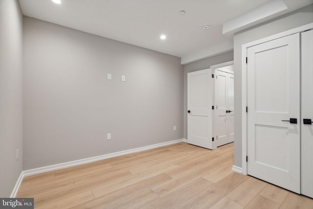 unfurnished bedroom featuring recessed lighting, light wood-style flooring, and baseboards