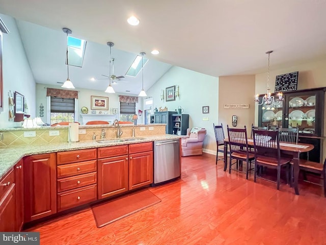 kitchen featuring a sink, wood finished floors, stainless steel dishwasher, and decorative light fixtures