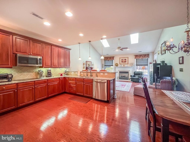 kitchen with visible vents, open floor plan, stainless steel appliances, pendant lighting, and a sink