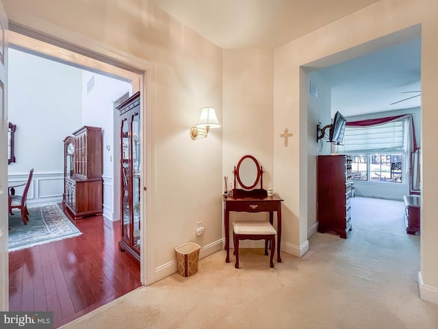 hallway featuring carpet and baseboards