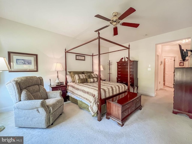 bedroom with ceiling fan, baseboards, and light colored carpet