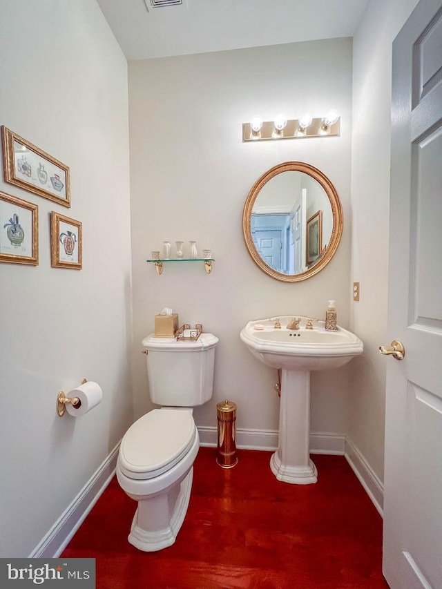 half bath with toilet and baseboards