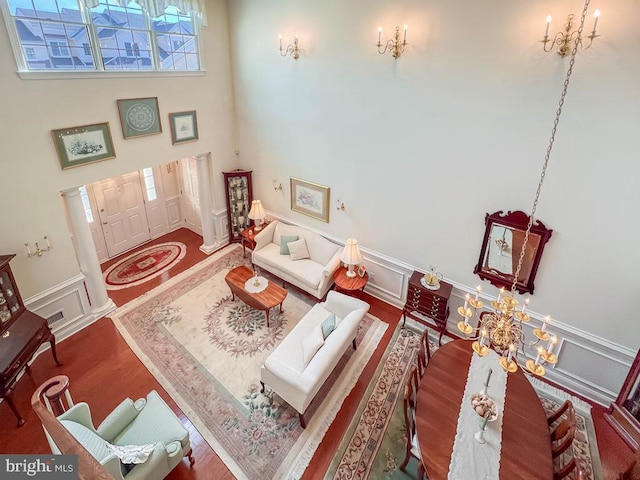 living room with a high ceiling, dark wood finished floors, and a notable chandelier