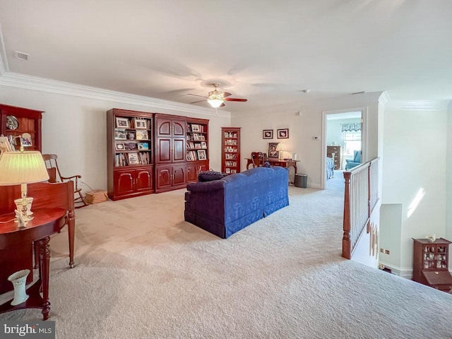 living area featuring crown molding, ceiling fan, visible vents, and light colored carpet