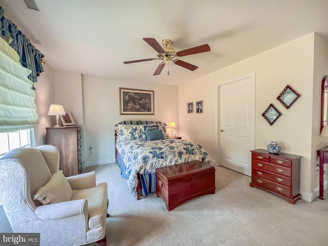 bedroom with a ceiling fan, light colored carpet, visible vents, and baseboards