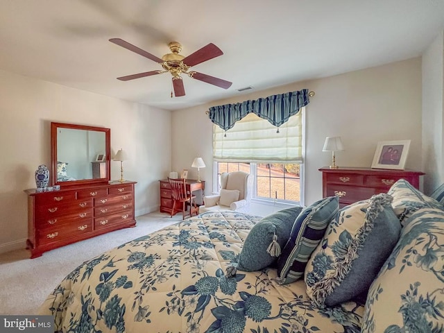 bedroom with light carpet, ceiling fan, visible vents, and baseboards