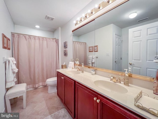 full bath with double vanity, a sink, and visible vents