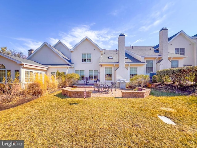 back of property featuring central air condition unit, a patio area, a chimney, and a yard