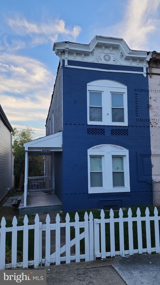 view of front of property featuring covered porch and a fenced front yard