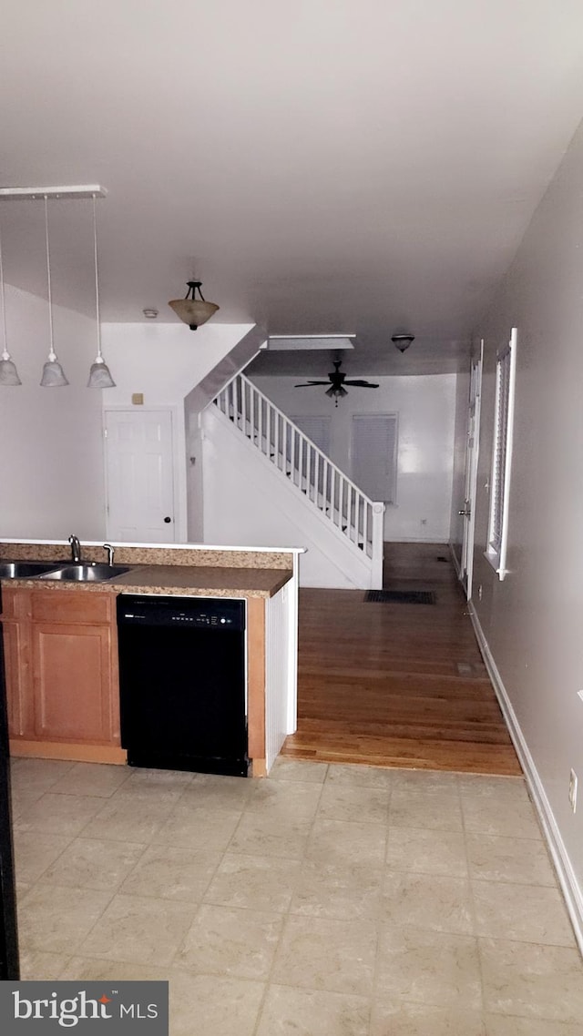 kitchen featuring black dishwasher, baseboards, a ceiling fan, pendant lighting, and a sink