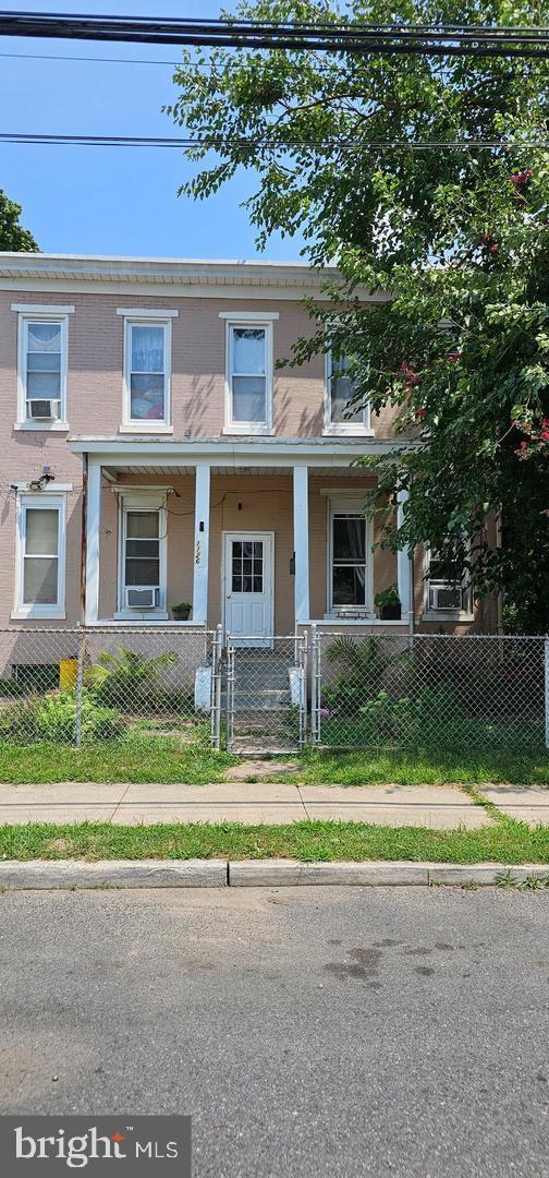 townhome / multi-family property featuring stucco siding, a fenced front yard, a gate, and brick siding