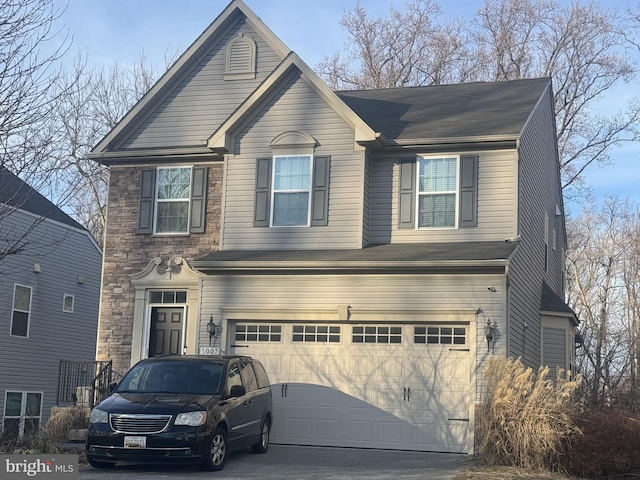 view of front of home featuring a garage, stone siding, and driveway