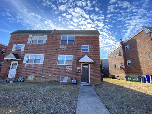 view of front of home with a front yard and brick siding